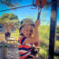 Kleiner Junge mit Gurtzeug und Schutzhelm auf einer Seilrutsche