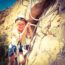 Young girl rock climbing on a Via Ferrata route