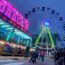 A fairground big wheel illuminated at night