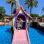 Small boy on a house-shaped slide in a swimming pool